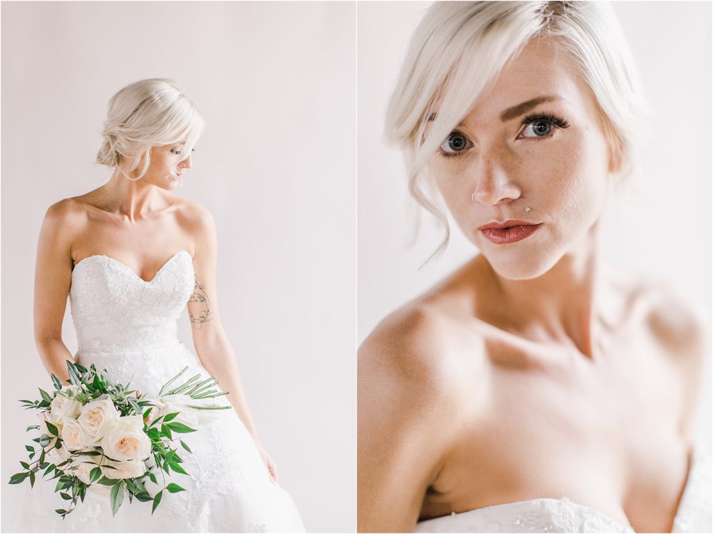 Bride in white wedding dress with a white backdrop and green florals